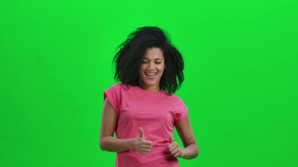 Портрет молодої афроамериканки, що зображає пальці вгору, жести. Чорна жінка з хвилястим волоссям на зеленому екрані в студії. Закрийся. Повільний рух готовий до 59.97fps. — стокове відео