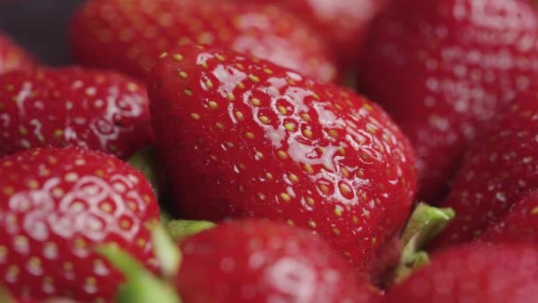 Fraises mûres juteuses recouvertes de gouttelettes d'eau tourner de près. Baies douces d'été avec queues vertes. Alimentation végétalienne biologique saine. Vitamine fruits sains. — Video