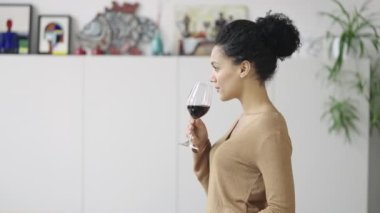 Genç Afrikalı Amerikalı kadının cam kadehten kırmızı şarap içişi. Şirin melez kadın lezzet ve içki kokusunun tadını çıkarıyor. Kapatın. Yavaş çekim hazır 59.97fps.