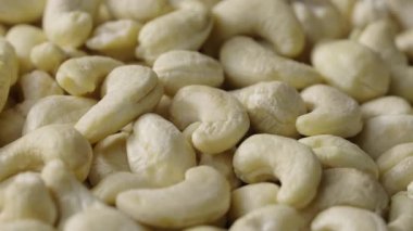 Taze kaju fıstığı. Çiğ kaju kabuklu fındık yığınının üzerine düşer. Lezzetli, sağlıklı fındık çekirdekleri. Organik sağlıklı gıda geçmişi. Yavaş çekim.
