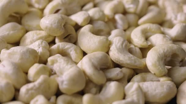 Ovanifrån av färska roterande cashewnötter. Kärnor av läckra friska nötter närbild. Hela nötkärnor. Nutty bakgrund, hälsosam mat, kost. Slow motion klar 59,94fps. — Stockvideo
