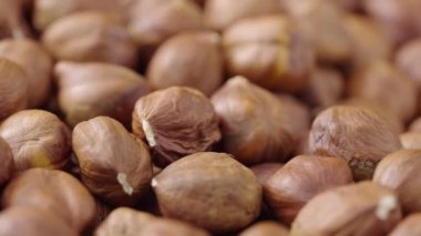 Dönen kabuklu fındıkların makro görüntüsü. Kurumuş kahverengi fındık çekirdekleri kapanıyor. Organik sağlıklı gıda geçmişi. Yavaş çekim hazır 59.94fps.