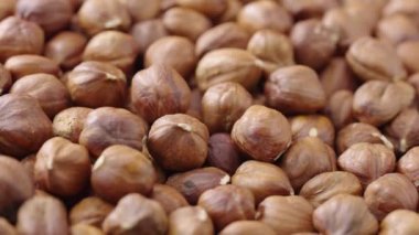 Dönen kabuklu fındıkların makro görüntüsü. Kurumuş kahverengi fındık çekirdekleri kapanıyor. Organik sağlıklı gıda geçmişi. Yavaş çekim hazır 59.94fps.
