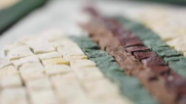 Bir mozaik oluşturma sürecinin detaylı makro görüntüsü. Küçük granit çakıl taşları cımbızla desene yerleştiriliyor. Yaratıcı bir atölyede dikiş işi. Kapatın. Yavaş çekim hazır 59.94fps.