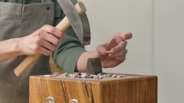 Erkek eller özel bir çekiçle mozaik fayansları ikiye böler. Mozaik desen oluşturmak için taş malzemelerin hazırlanması. Yaratıcı bir atölyede el yapımı. Kapatın. Yavaş çekim.