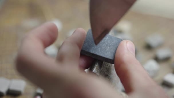 Mannelijke handen breken de mozaïektegels in tweeën met een speciale hamer. Voorbereiding van stenen materiaal voor het leggen van een mozaïek patroon. Handgemaakt in een creatieve werkplaats. Sluit maar af. Langzame beweging. — Stockvideo