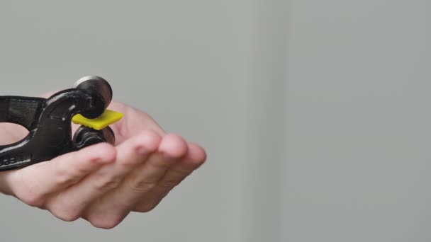 Mannelijke handen snijden een stuk steen met behulp van een speciale nippers tool. Een helder geel stuk mozaïeksteen wordt in tweeën gehakt. Handgemaakt in een creatieve werkplaats. Sluit maar af. Langzame beweging — Stockvideo