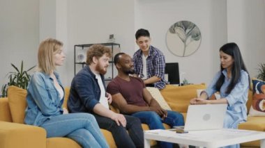 İş arkadaşları birlikte çalışıyor, takım çalışmasını tartışıyor ve yeni bir iş projesi başlatıyorlar. Çok uluslu bir grup insan gayri resmi bir iş ekibi toplantısı yapıyor. Yavaş çekim.