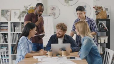 Meslektaşlar yeni bir strateji hakkında konuşuyor. Çok ırklı bir grup insan evrak işlerini analiz eder brifing masasında toplanır, modern ofiste başlangıç projesi planını tartışırlar. Yavaş çekim.
