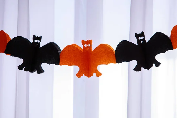 Guirlanda de papel de Halloween com laranja e morcegos pendurados no fundo da janela. Artesanato fácil para crianças. Férias, decorações e conceito de festa. Fechar. — Fotografia de Stock