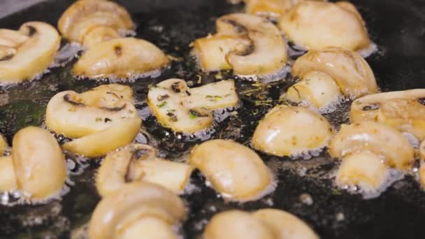 Le fette d'oro di champignons con cipolla e condimento vengono fritte in una padella calda con olio da vicino. Delizioso piatto di funghi. Bella carta da parati di cottura per il ristorante. Rallentatore. — Video Stock