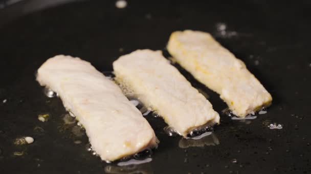 Strippen kipfilet worden gebakken in olie in een hete pan. Sappige stukjes kalkoen zijn gebakken. Close-up shot van het koken sappige gezonde vleesschotel. Mooi behang van koken voor restaurant. Langzame beweging. — Stockvideo