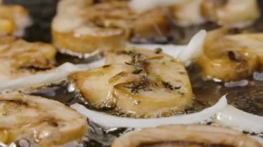 Şampiyonların soğan ve baharatlı altın dilimleri sıcak bir tavada kızartılıp yağla kaplanır. Lezzetli mantar yemeği. Restoran için güzel bir duvar kâğıdı. Yavaş çekim.