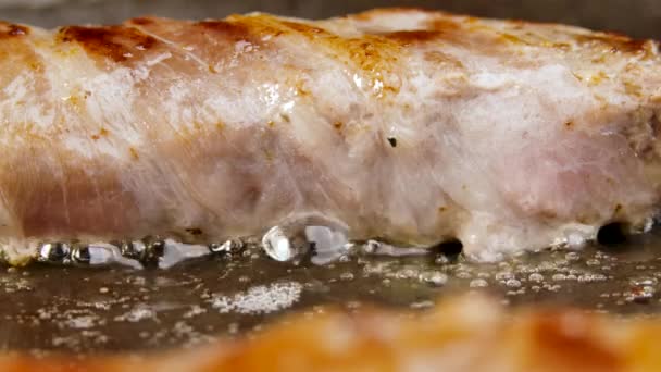 Preparazione di piatto di carne da carne macinata avvolta in pancetta con venature bianche. I chevapchichi sono fritti in una padella calda sott'olio. Bella carta da parati di cottura per il ristorante. Al rallentatore. Da vicino.. — Video Stock