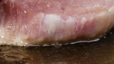 Domuz bifteği tereyağına düşer. Et tabağı kızartma işleminin yakın plan çekimi. Yemek pişiriyorum. Restoran için güzel bir duvar kâğıdı. Yavaş çekim.