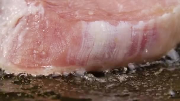 Schweinesteak fällt in einer heißen Pfanne in Butter. Nahaufnahme des Prozesses, ein Fleischgericht zu rösten. Abendessen kochen. Schöne Tapete des Kochens für Restaurant. Zeitlupe. — Stockvideo