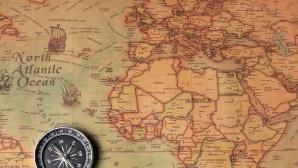 Kompas liggend op de oude kaart. Een ouderwets instrument werd gebruikt in de zeevaart voor navigatiedoeleinden op de leeftijd van grote geografische ontdekkingen. — Stockvideo