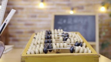 Boş bir okul sınıfının arka planındaki abaküs tahtayla, yakın plan. Okul, ev eğitimi, uzaktan öğrenme. İlkokulda aritmetik dersi. İlkokulda öğrenim.