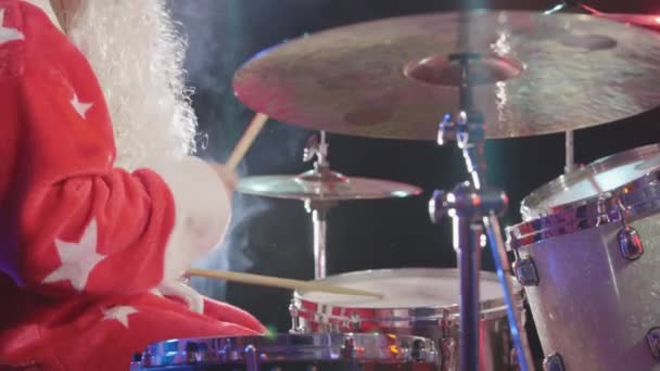 Side view of drummer in carnival costume of Santa Claus with a beard beats with sticks on drums and percussion cymbals, creating a melody. Close up. Slow motion. — Stock Video