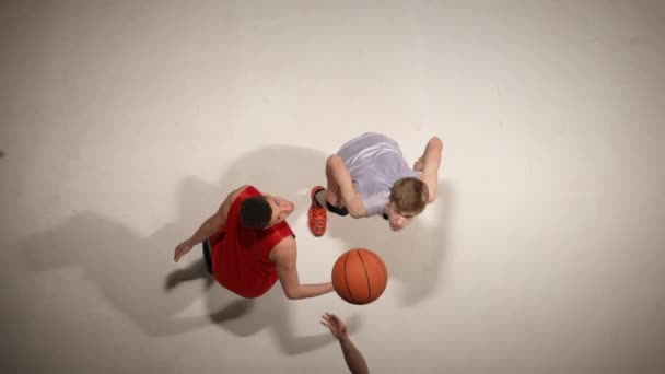Top view of throw-in of the ball before the start of the game in basketball competition. Two opposing players jumping for possession of the ball. Slow motion. — Stock Video