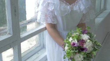 Vintage beyaz elbiseli güzel kız pencere üzerinde oturan çiçek, yavaş hareket