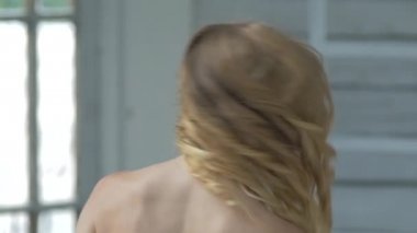 Young cute smiling girl waves her hair, slow motion