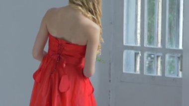 Young cute girl waves her hair, smiling and ups the flowers, cam moves upward, slow motion