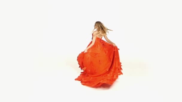 Beautiful girl in gorgeous red dress whirling, isolated on white,  slow motion — Stock Video