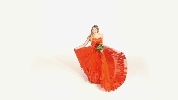 Beautiful girl in gorgeous red dress with bouquet of flowers whirling, isolated on white, slow motion