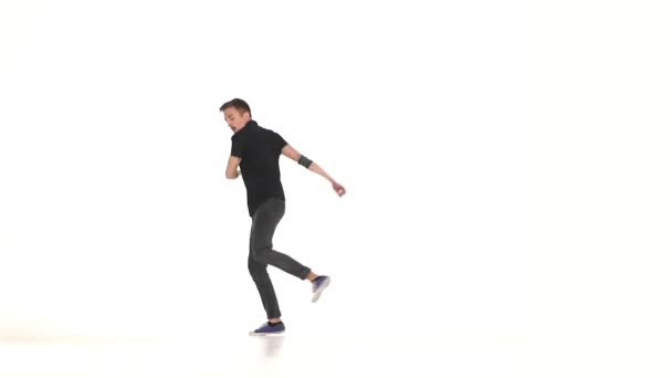 Молодой, стильный мужчина продолжает танцевать тормозные движения, на белом, замедленном движении — стоковое видео