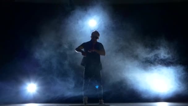 Um hip hop break-dançarino homem elegante em óculos de sol começa a dançar, fumaça, silhueta, câmera lenta — Vídeo de Stock