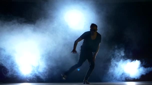 Young hiphop dancer starts making a move, smoke, silhouette, slow motion — Stock Video