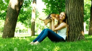 doğada oynayan bir köpek beagle ile mutlu kız