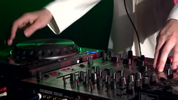 Χέρια DJ σε κομψό κατάστρωμα εξοπλισμού, χορεύοντας και παίζοντας, κοντινό, πράσινο οπίσθιο φωτισμό — Αρχείο Βίντεο