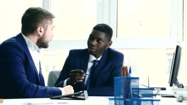 Young people are messy discuss something. One of the businessmen - African American