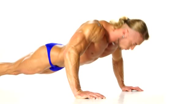Bonito homem muscular fazendo push-up no fundo branco — Vídeo de Stock