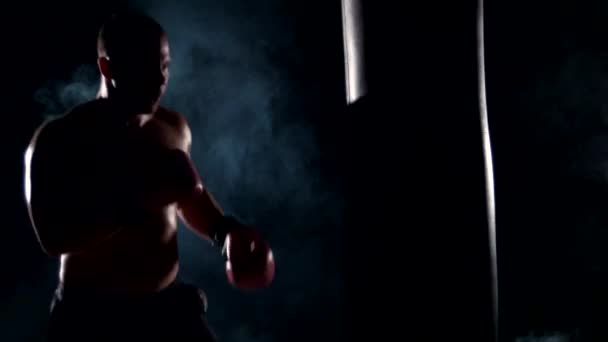 Μπόξερ άνθρωπος κατά τη διάρκεια πυγμαχία κτυπώντας βαριά τσάντα σε κατάρτιση γυμναστήριο — Αρχείο Βίντεο