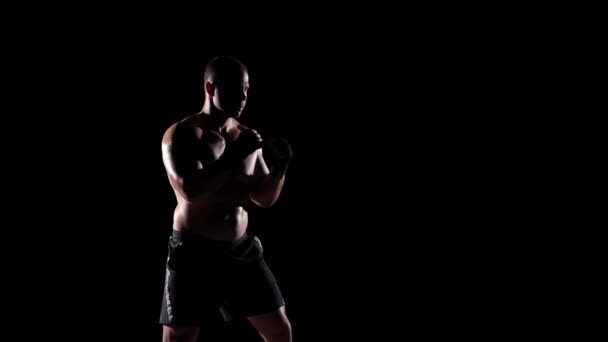 Boxer tränings skugga boxning över svart bakgrund. Slow motion. — Stockvideo