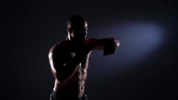 Boxeador entrenamiento sombra boxeo sobre fondo negro. Movimiento lento . — Vídeo de stock