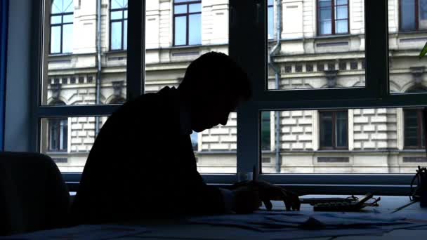 Silhouet jonge man werkt, hij kan niet, gooit het papier. Slow Motion — Stockvideo