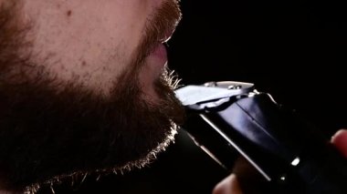 Bıyığını ve sakalını kesmek için genç bir adam. Usta çok dikkatli çalışır. Yavaş çekim