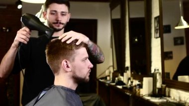 Şık iç mekan: Berber kendine bakarken saç istemcisi kurutur. Yavaş çekim