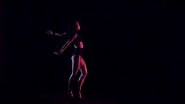 Seksi kadın dans, karanlık arka plan. Yavaş çekim.