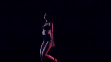 Seksi kadın dans, karanlık arka plan. Yavaş çekim.