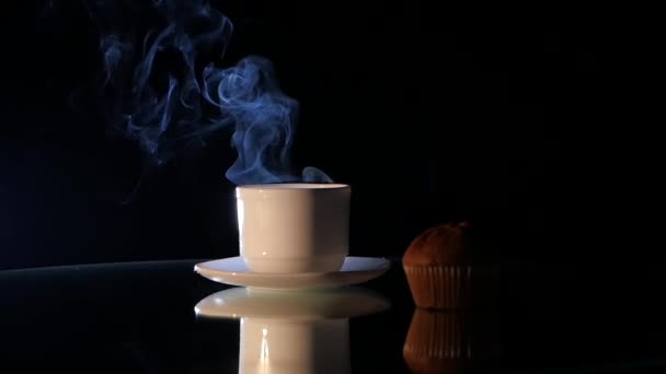 Heißer Kaffee in weißer Tasse mit Kuchen auf schwarzem Hintergrund — Stockvideo