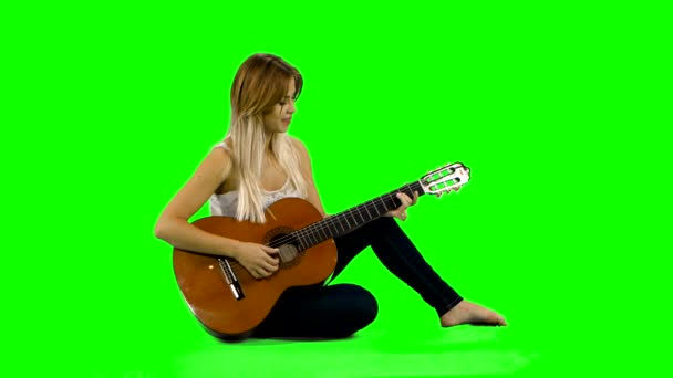 Fiatal, gyönyörű, kaukázusi nő alkalmi gitáron. Zöld képernyő — Stock videók