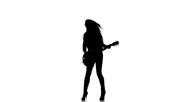 Silhouette d'une jeune fille jouant de la danse à la guitare électrique sur fond blanc . — Video