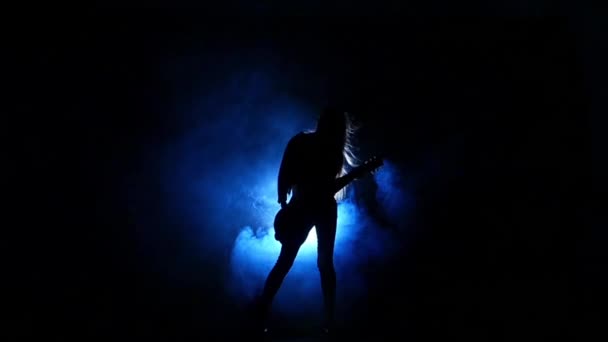 Sziluettje egy fiatal lány játszik az elektromos gitár. Lassított mozgás. — Stock videók