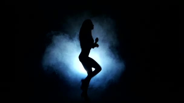 Eine sexy Stripperin Showgirl in Silhouette Studio isoliert auf dunklem Hintergrund — Stockvideo