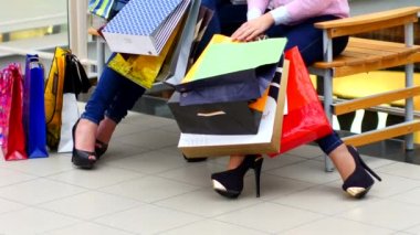 Alışveriş poşetleri ile iki güzel kız alışveriş merkezinde satın izlemek